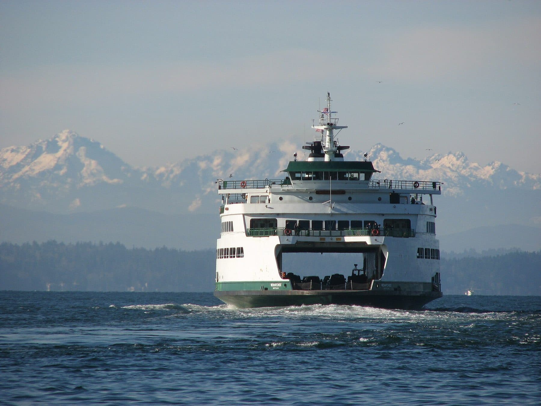 Washington State Ferry MV Wenatchee crossing Puget Sound toward Bainbridge Island with the snowy Olympic Mountains behind.