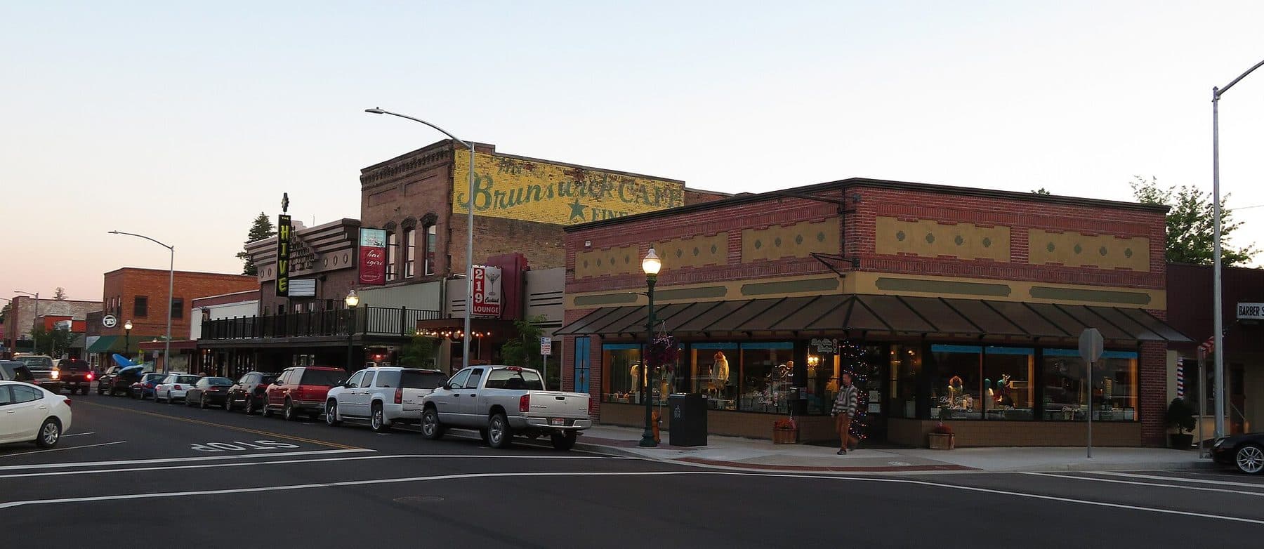 Historic brick storefronts along First Avenue in downtown Sandpoint, Idaho, at dusk.